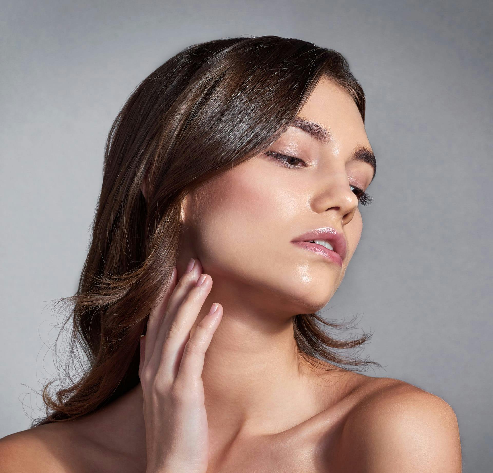 Woman brushing hand against neck