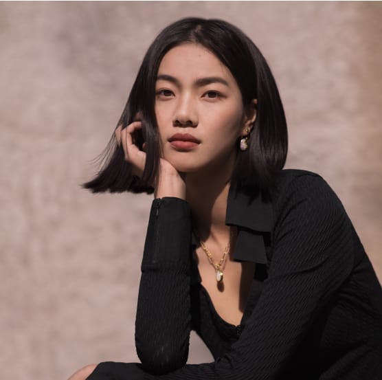 Asian woman with a hand to her chin