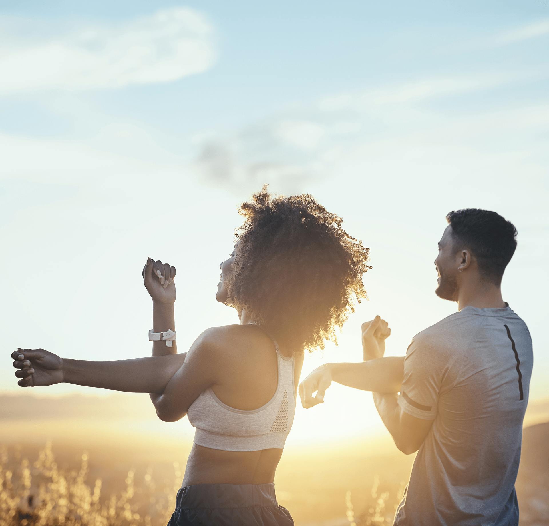couple stretching their arms outside