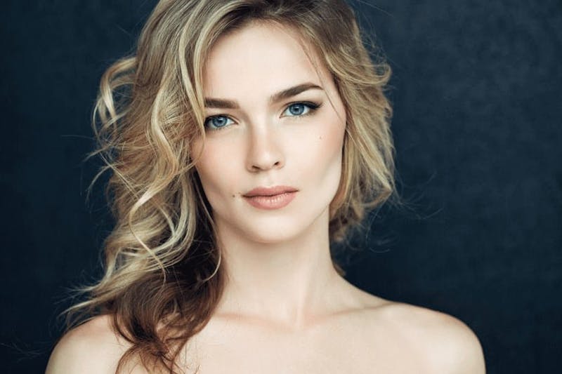 woman with blonde curly hair and blue eyes