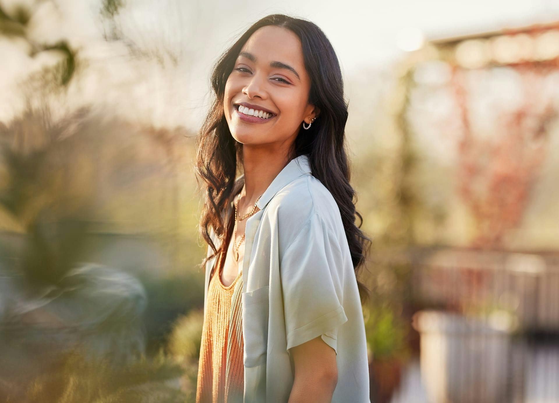 woman with lond wavy dark hair smiling