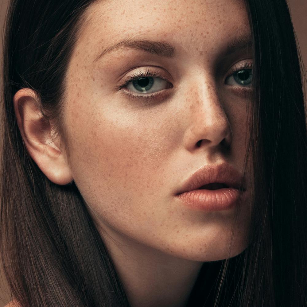 Woman looks seductively at the camera with long dark hair. Her firm and smooth skin show the potential results of JOULE X in Boston with Neem