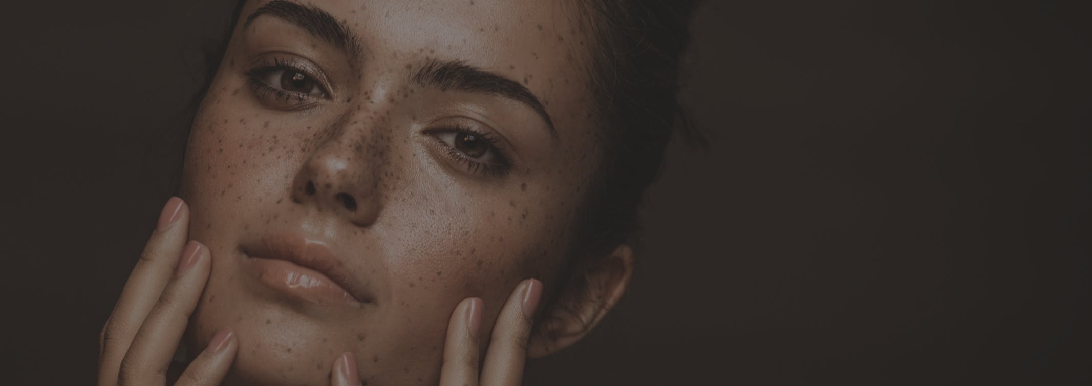 Woman looks seductively at the camera with hands on her face. Her firm and smooth skin show the potential results of JOULE X in Boston with Neem