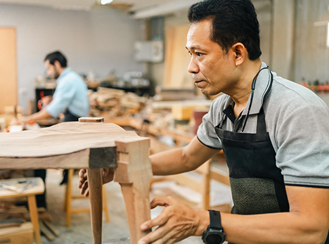Carpenter builds wooden chair in workshop