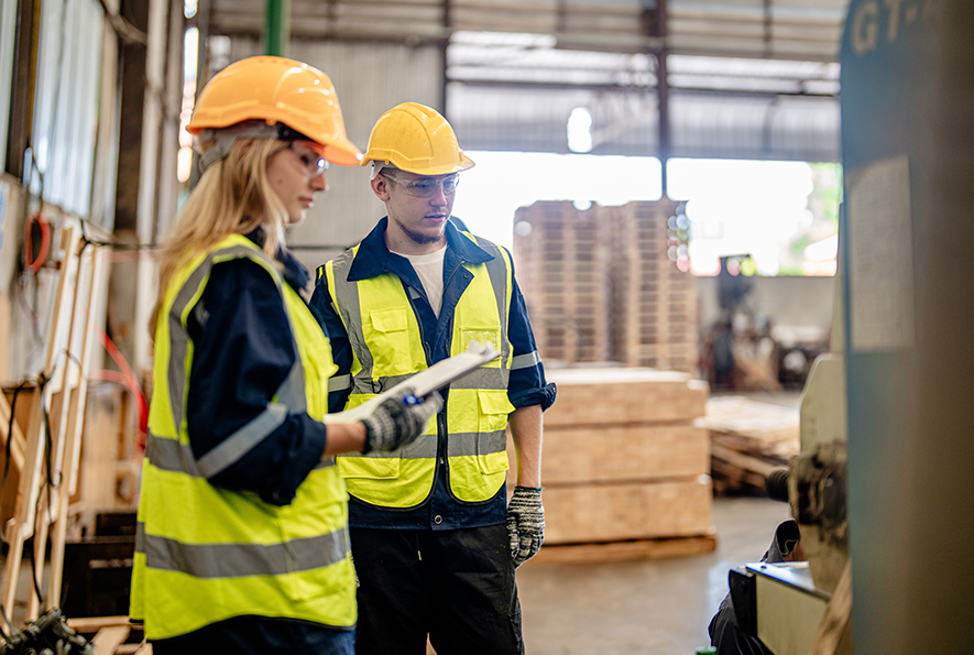 Man and woman wearing safety gear working in a warehouse