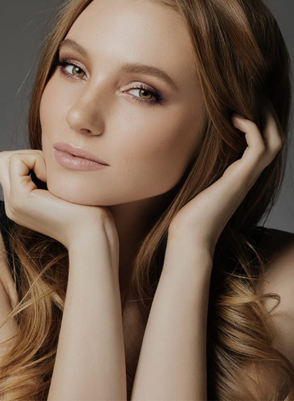 Woman looking into the camera with a hand under her chin