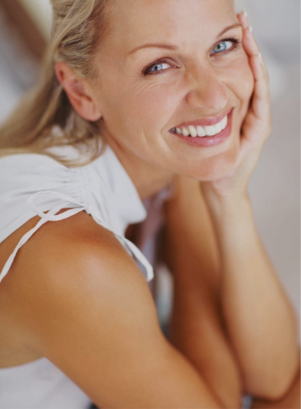 Smiling woman with a hand to her cheek