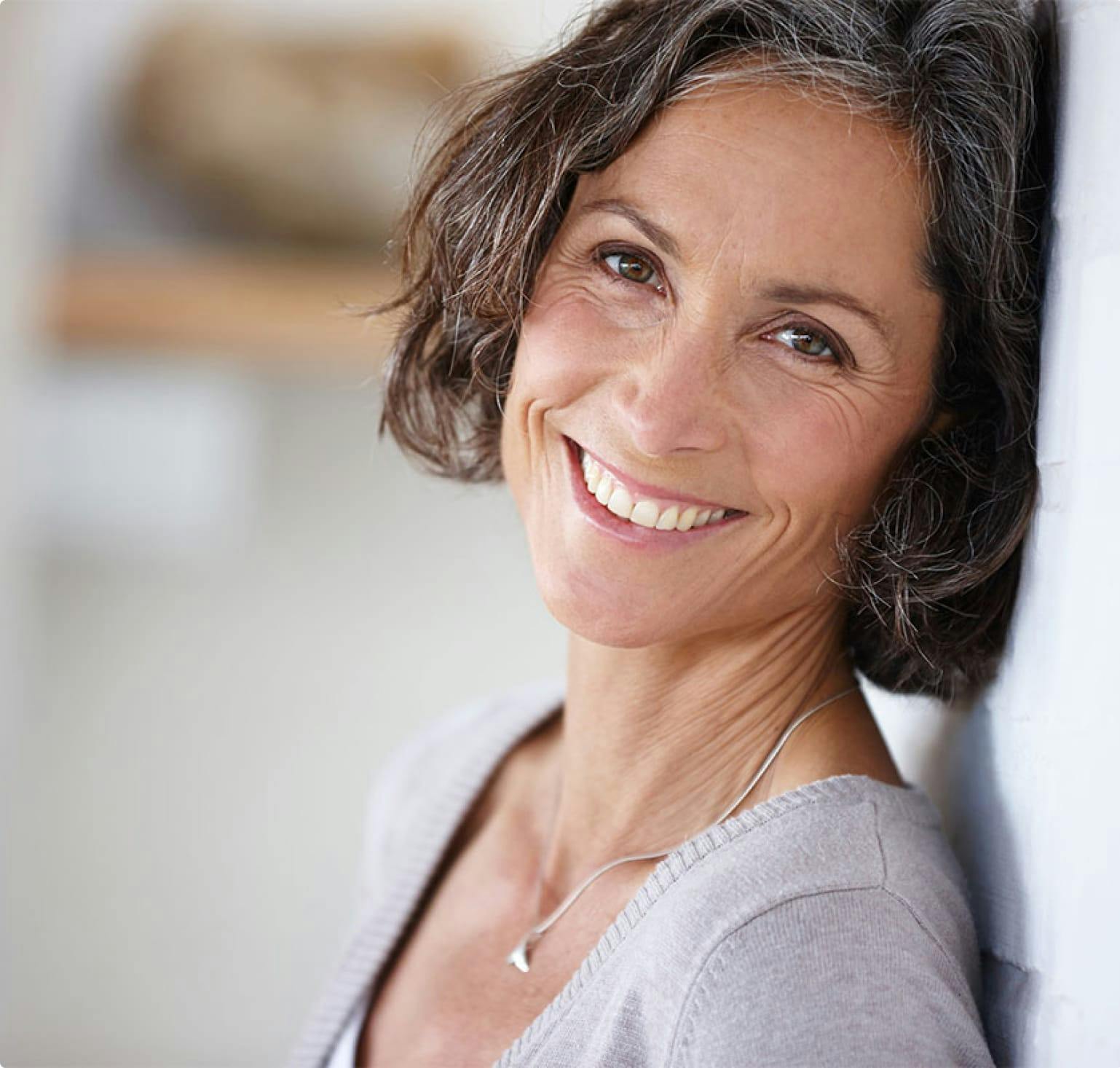 Smiling woman with her back to the wall