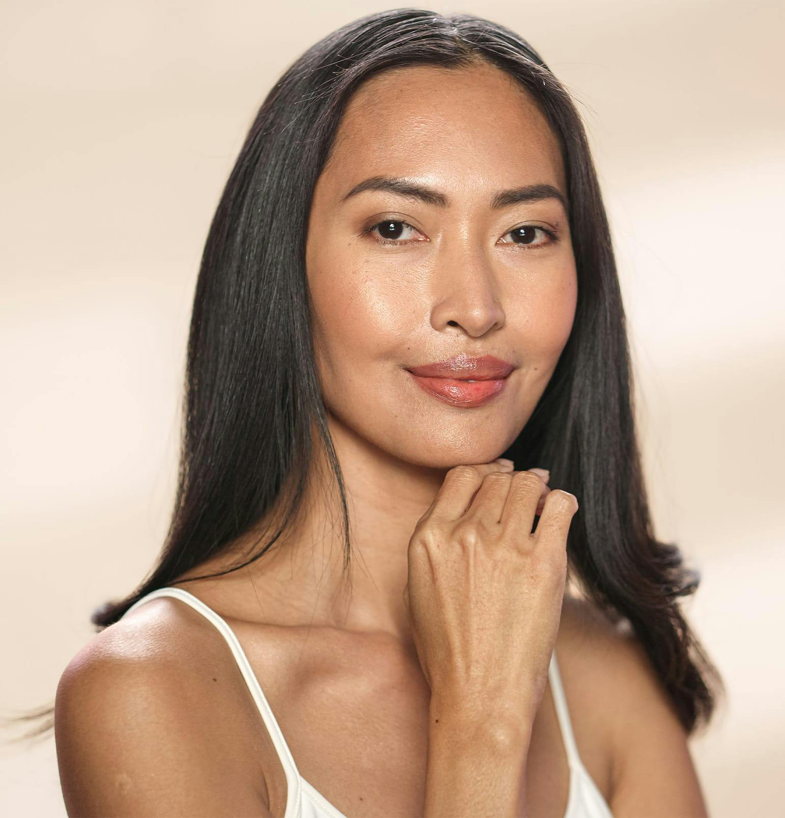 woman with straight hair with hand under her chin
