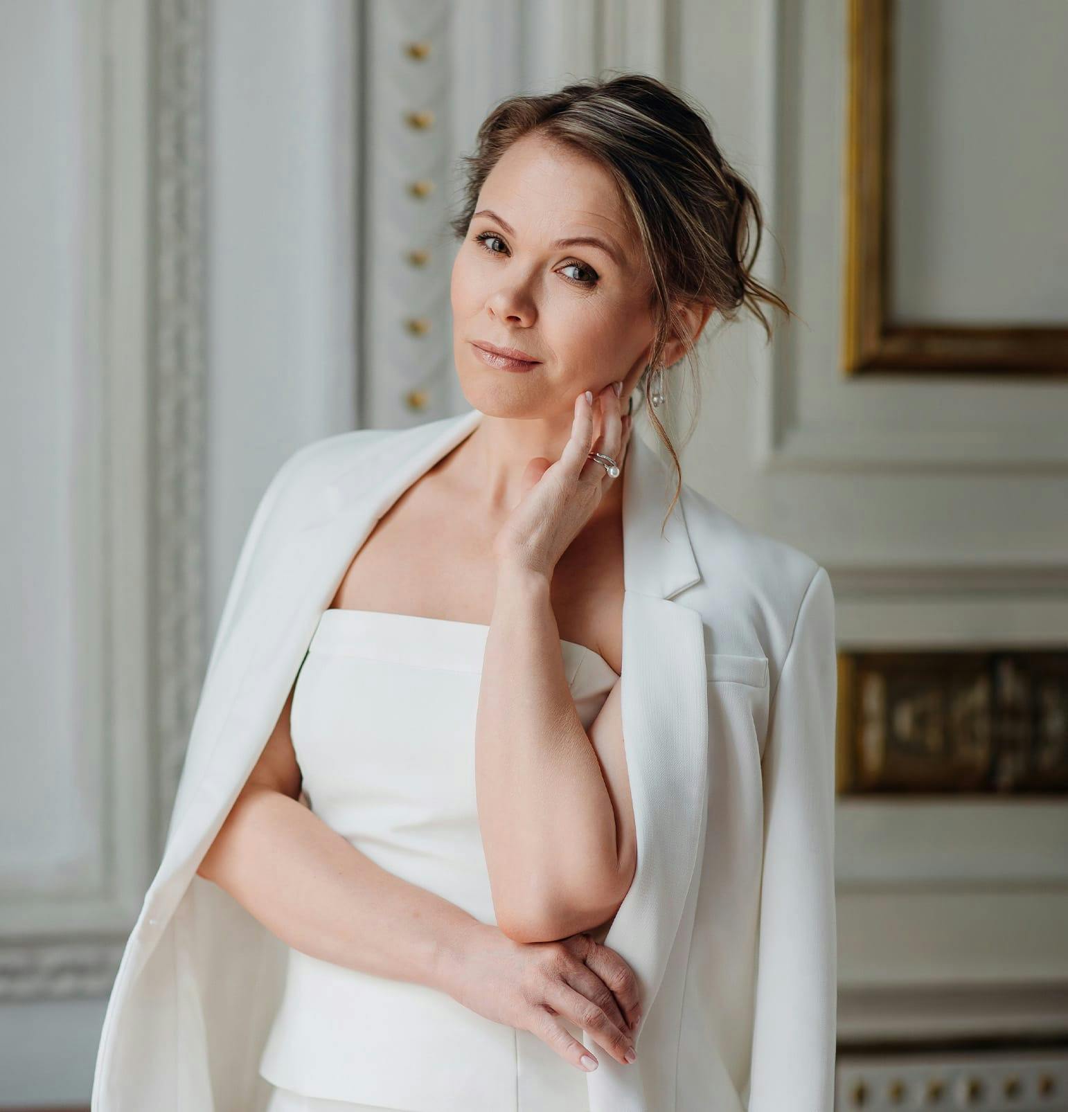 woman in white dress with white jacket posing