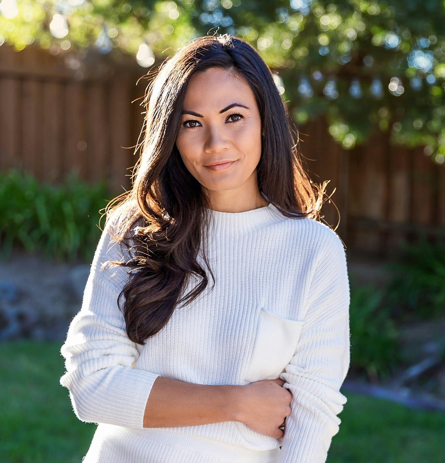 woman with long brown hair with her hand grabbing her own waist