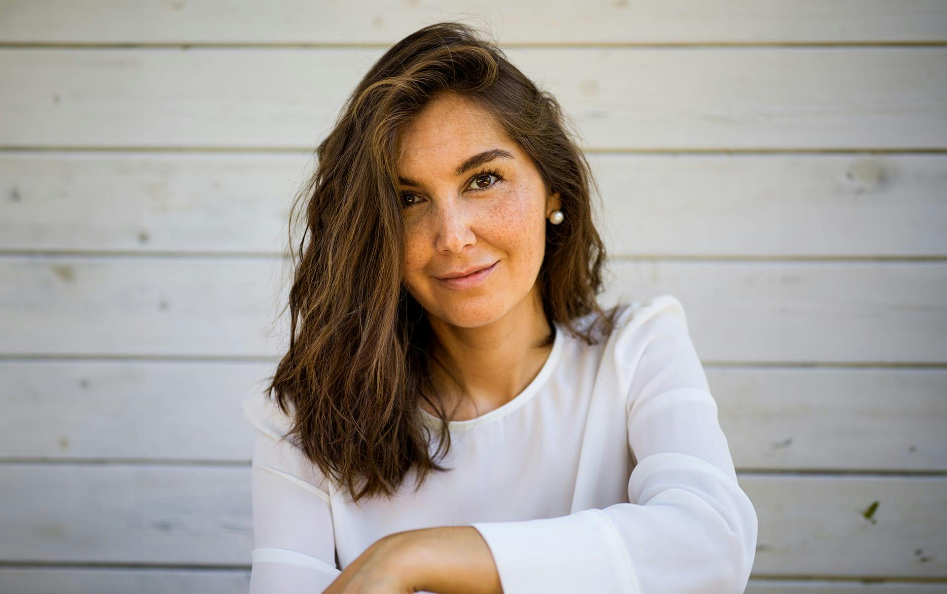 woman with freckles in white shirt