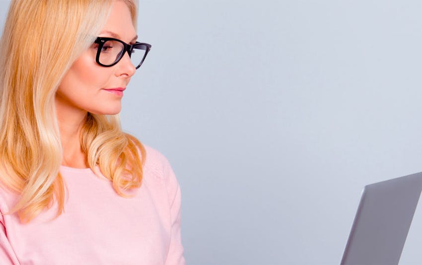 woman looking at laptop with glasses