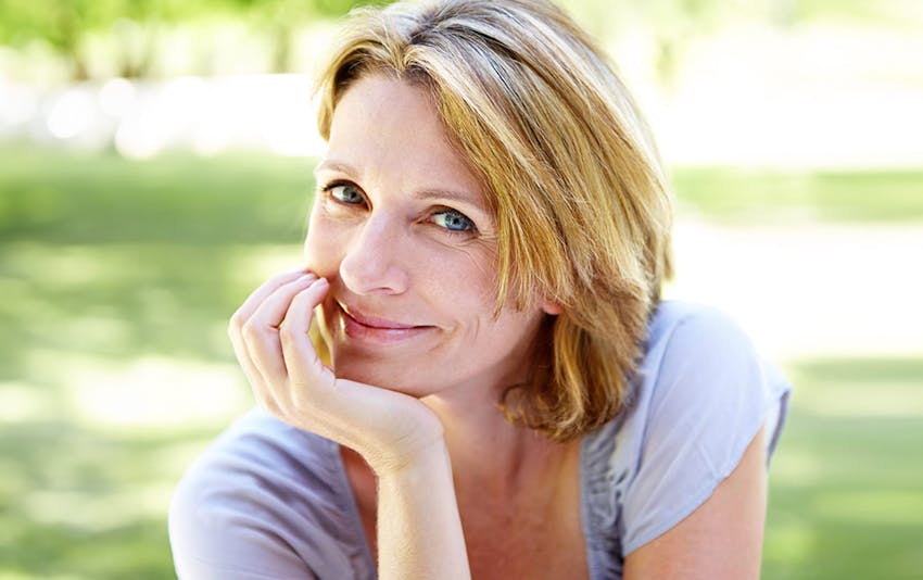 woman with short hair resting chin in her hand