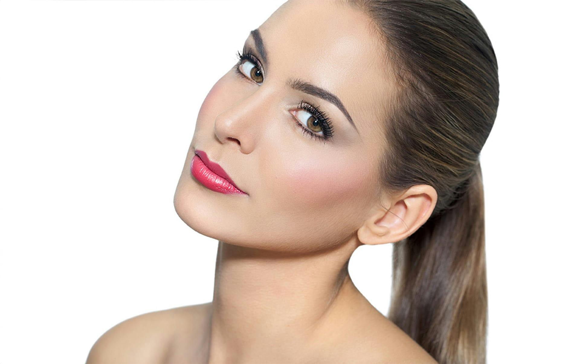woman with hair up smiling tilting her head to the left