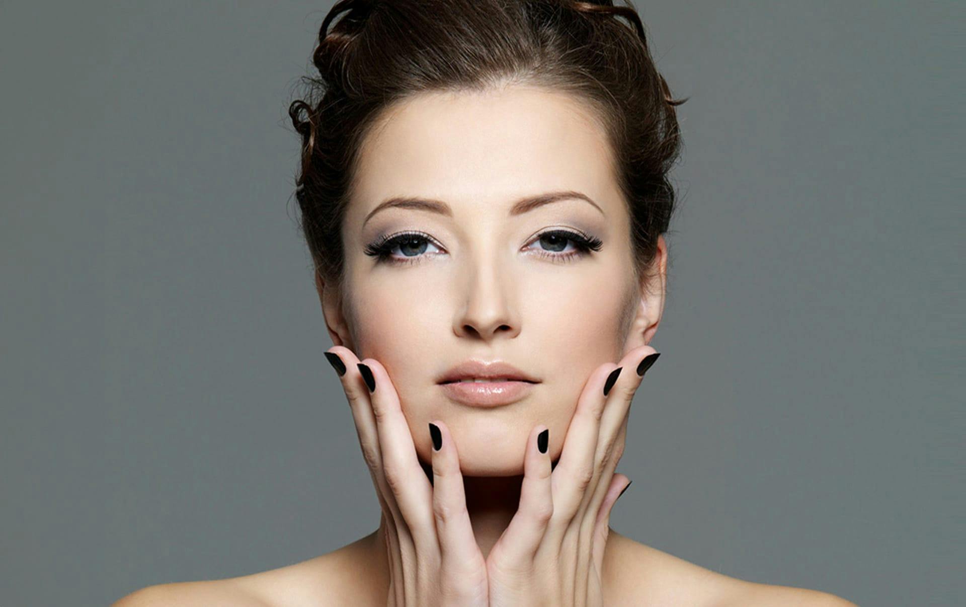 woman touching her jaw with hair tied up