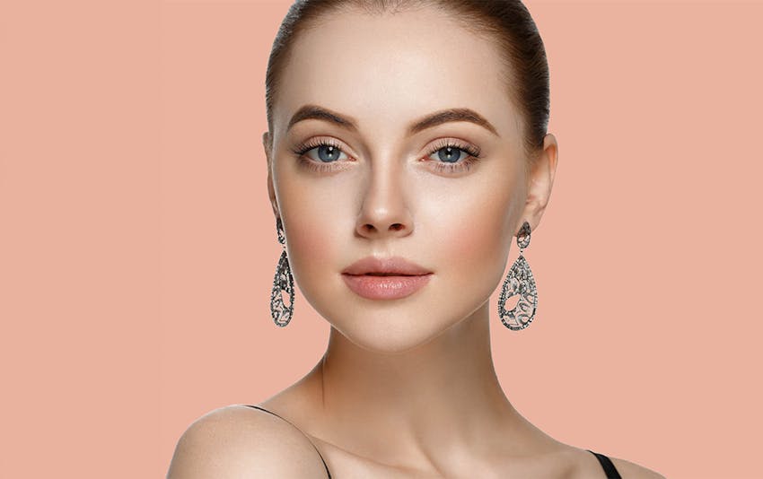 woman with long earrings with slick bun