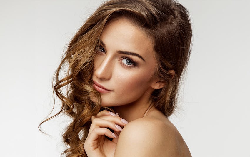 woman with curled hair looking over her shoulder