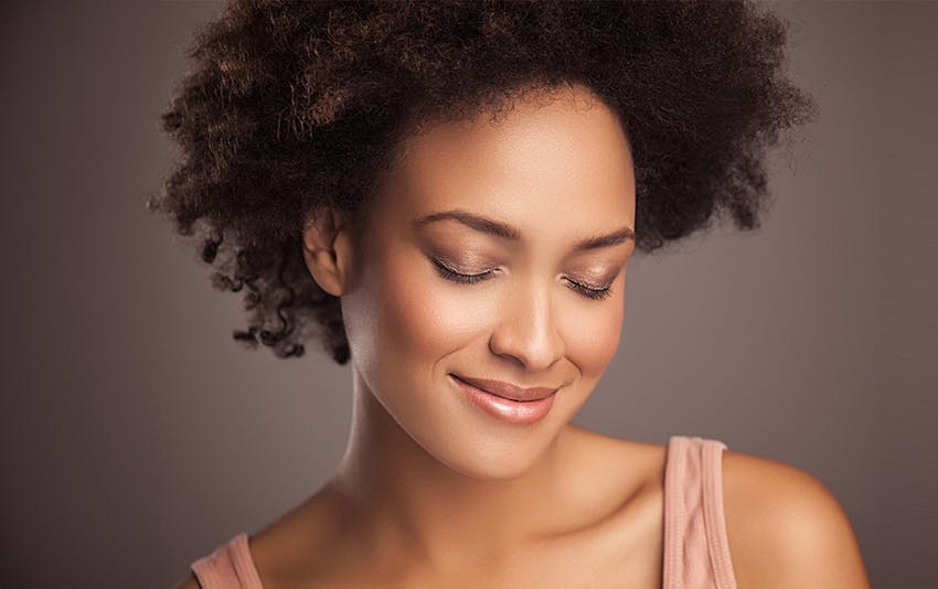 woman with afro closing her eyes