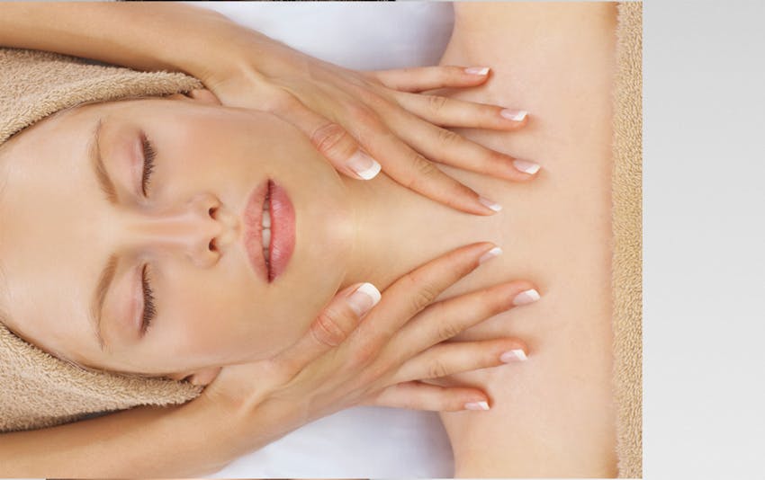 woman getting a facial with towel on her and wrapping her hair