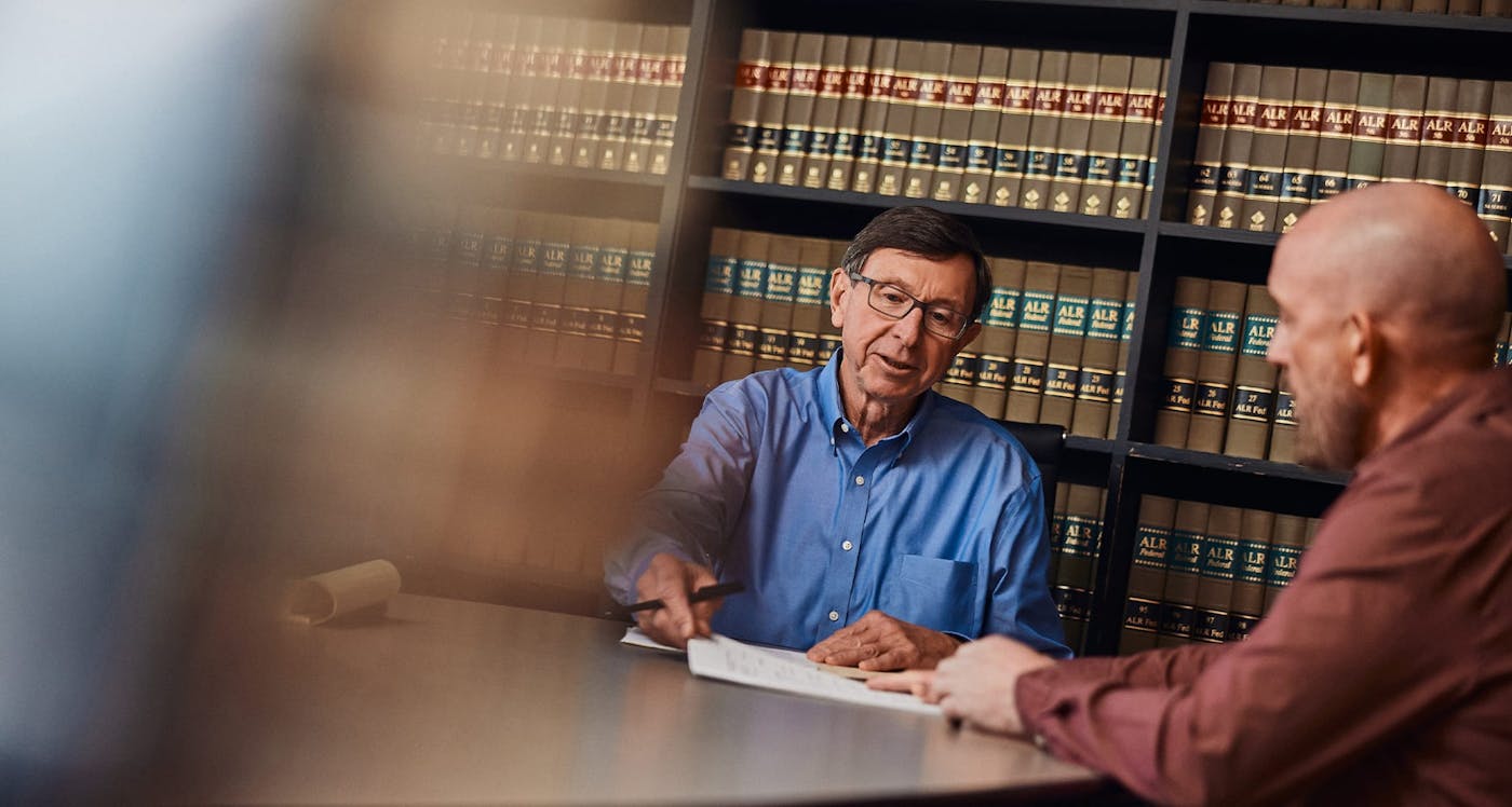 men sitting at table with papers