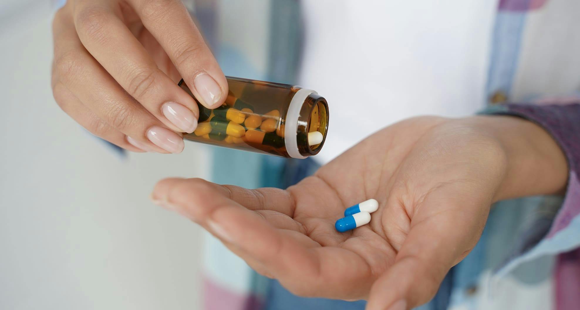 pills falling into woman's hand