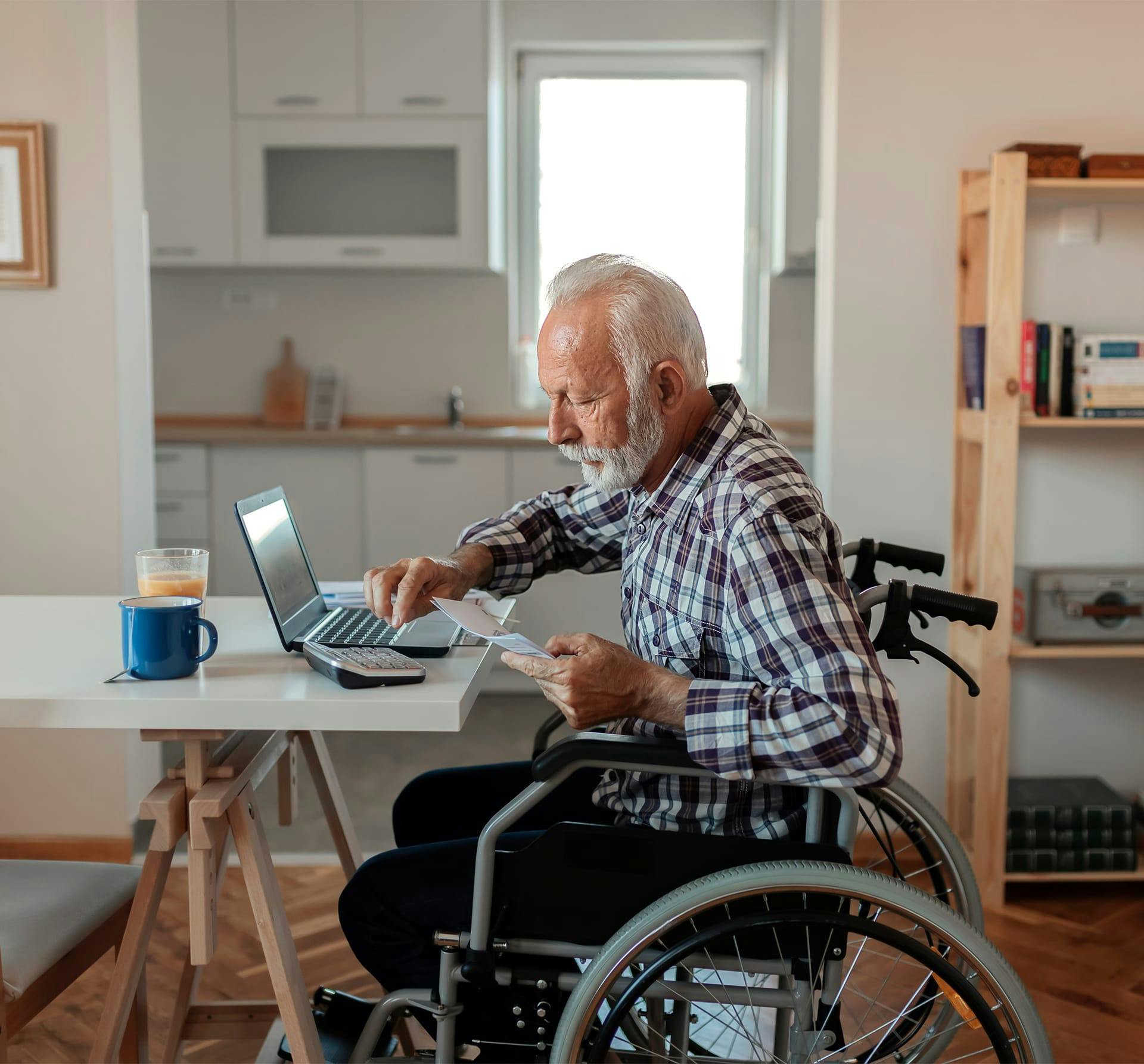 older man in wheelchair on laptop