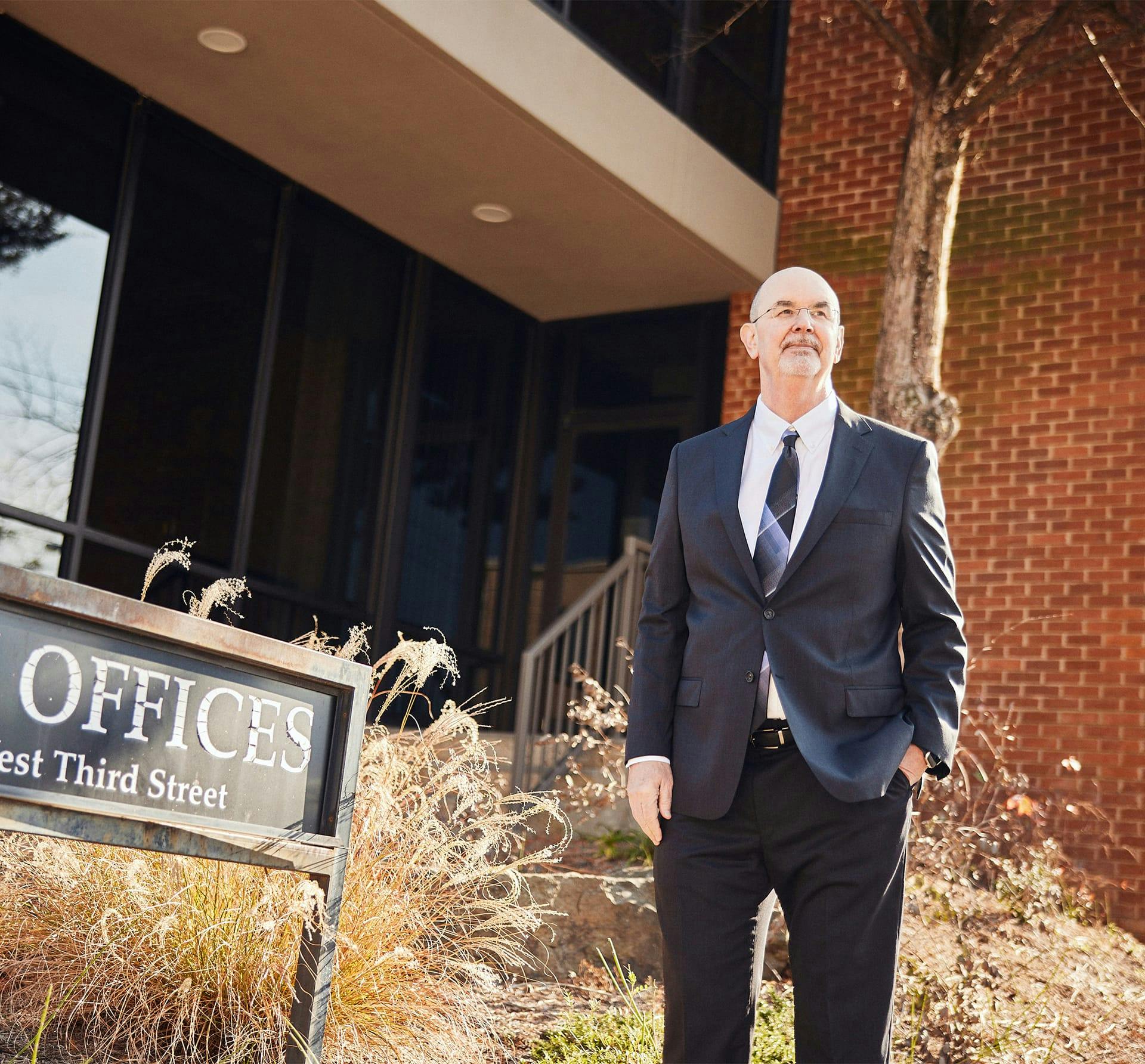 attorney standing next to sign of office