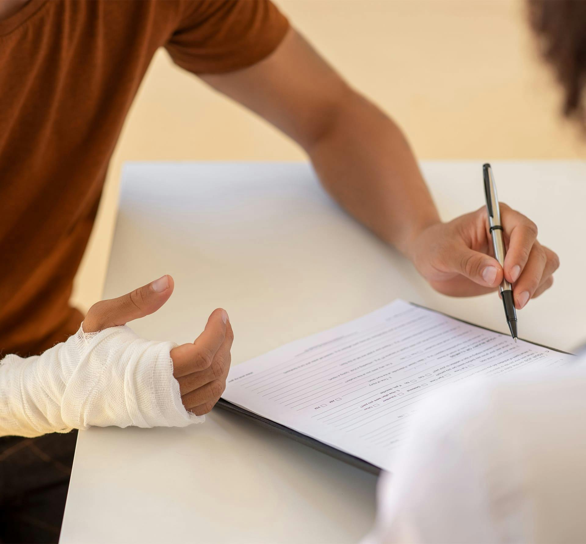 man in cast signing paper