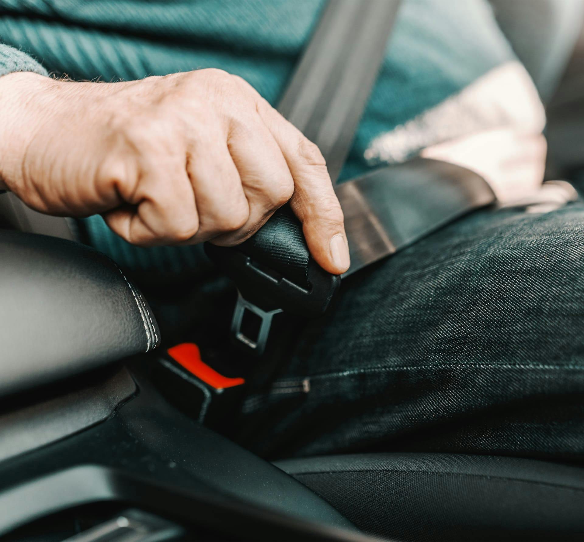 close up of man putting seat belt on