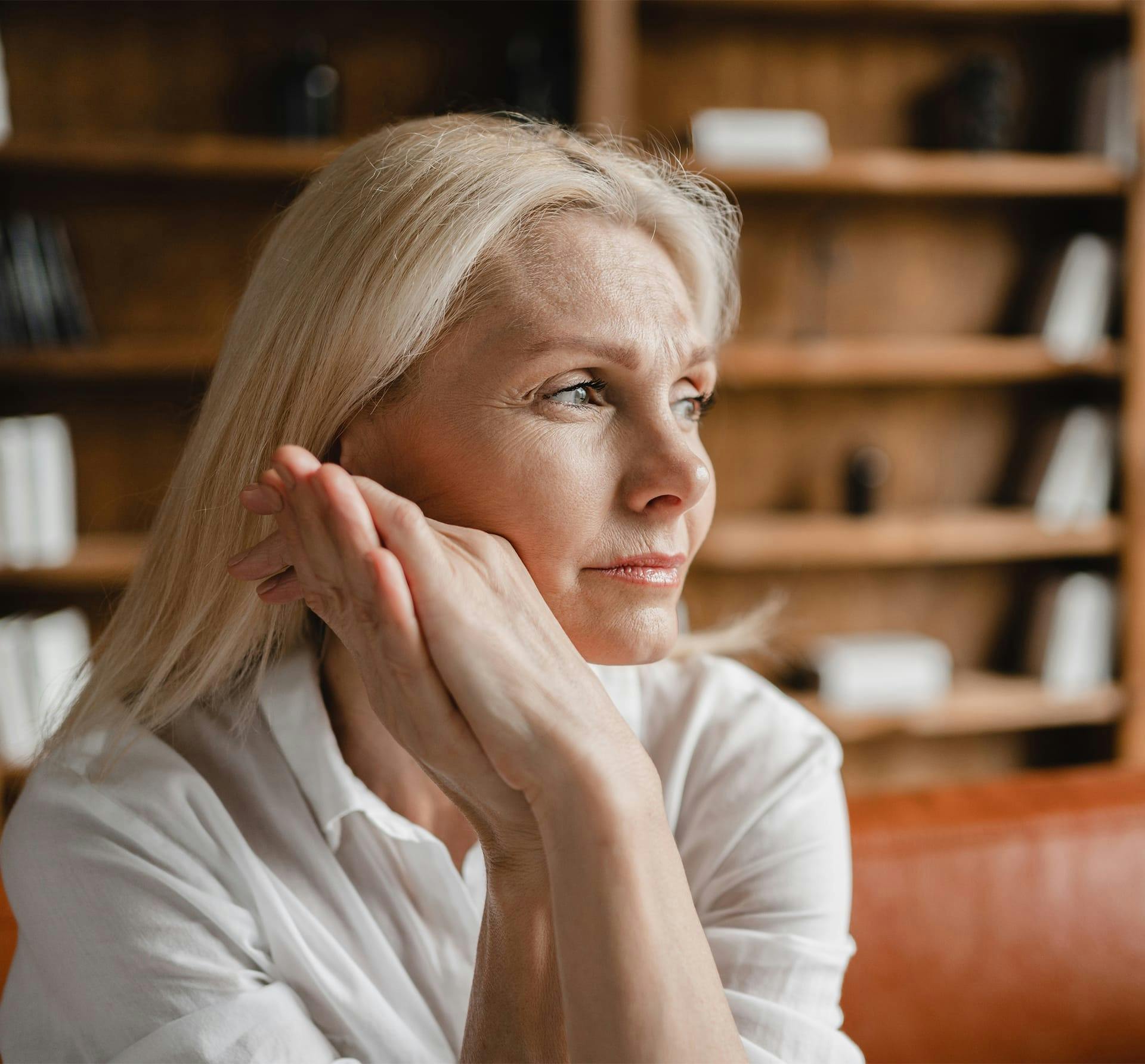 older woman resting head on her hands