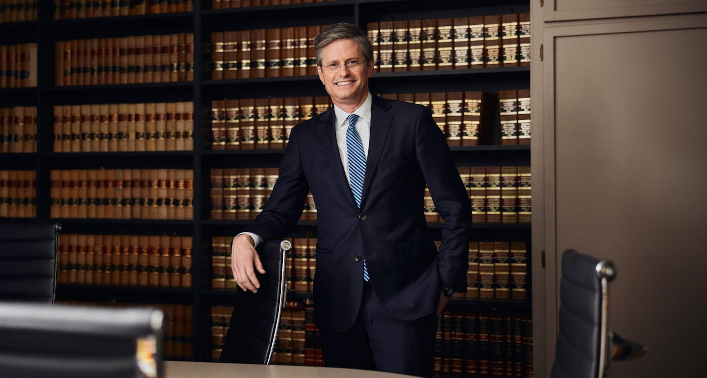 man leaning on office chair in suit