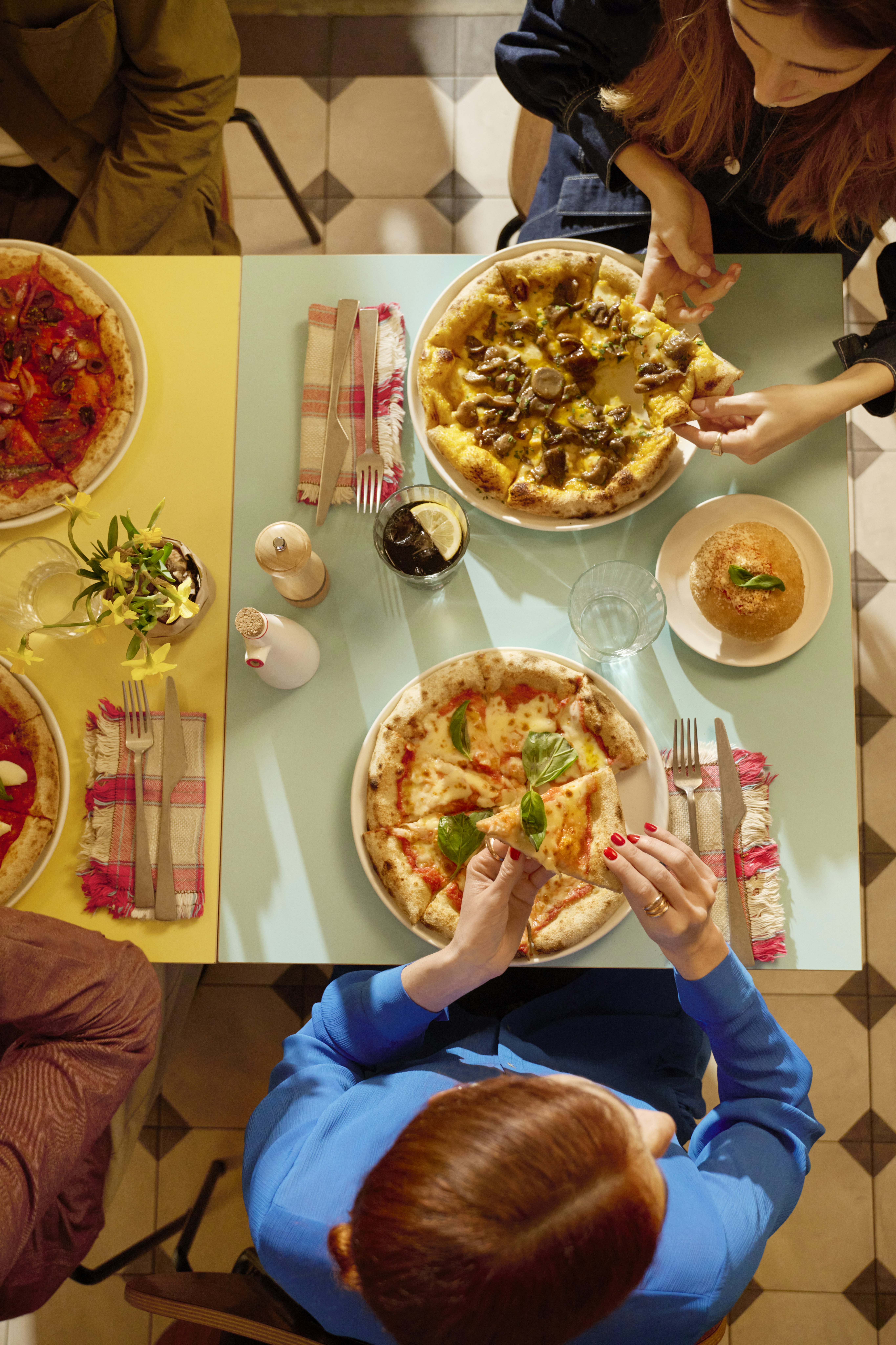 Amici che mangiano una pizza assieme e pagano con Satispay