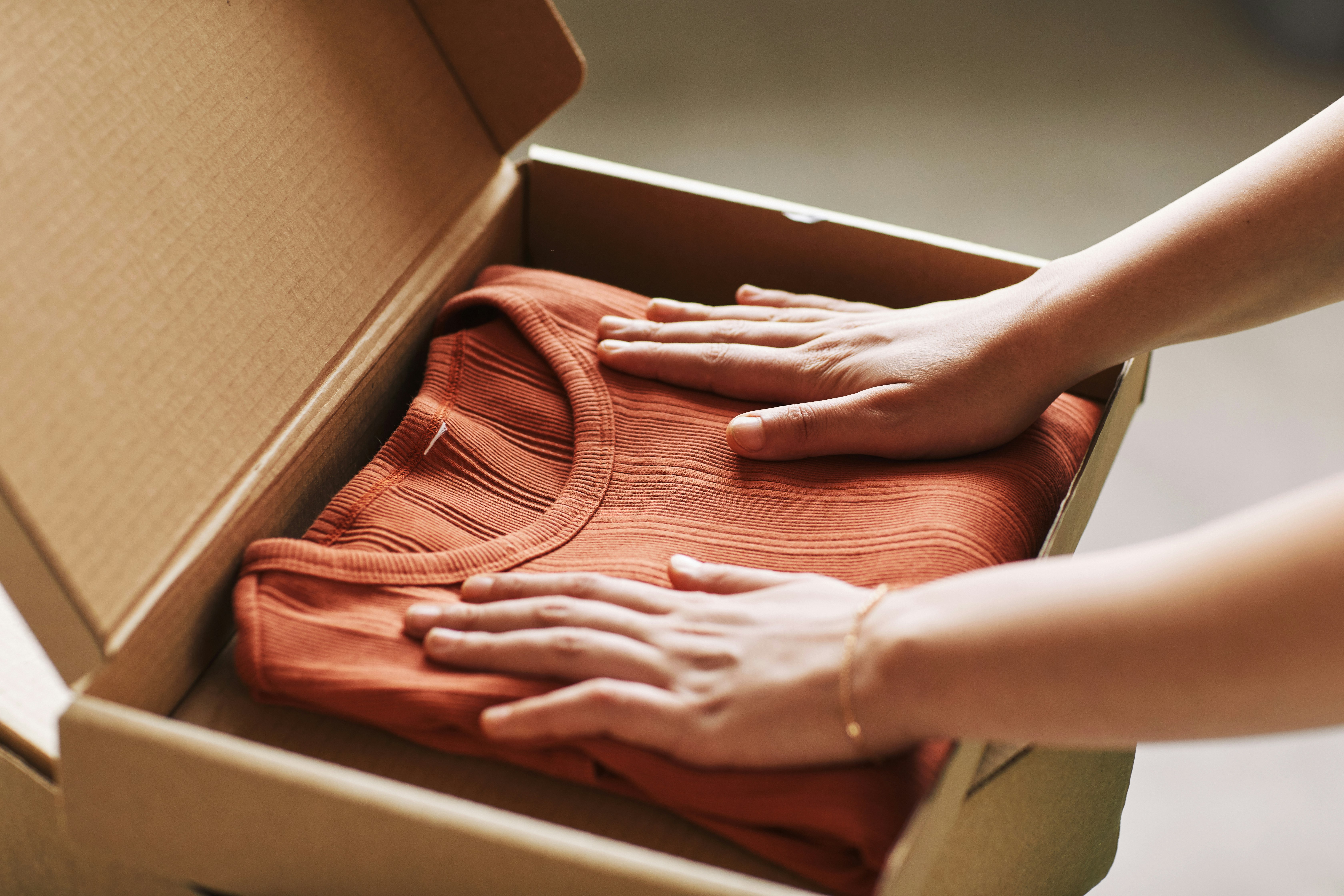 Una persona apre un pacco pagato online con Satispay