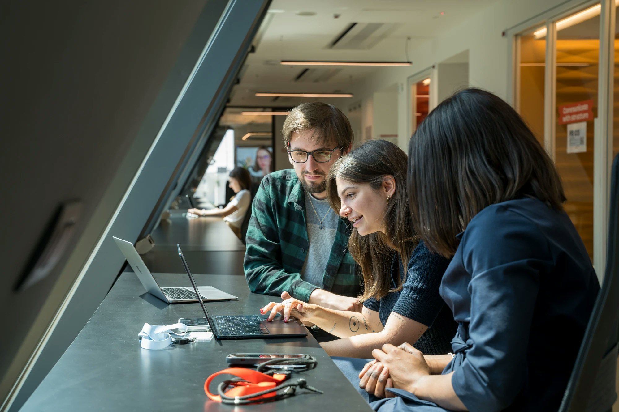 Tre persone collaborano al computer negli uffici Satispay