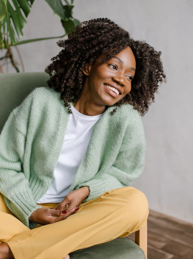 woman with very curly dark hair wearing a green cardigan