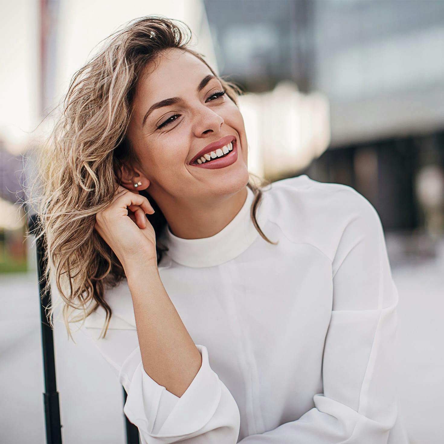 woman smiling, playing with her hair