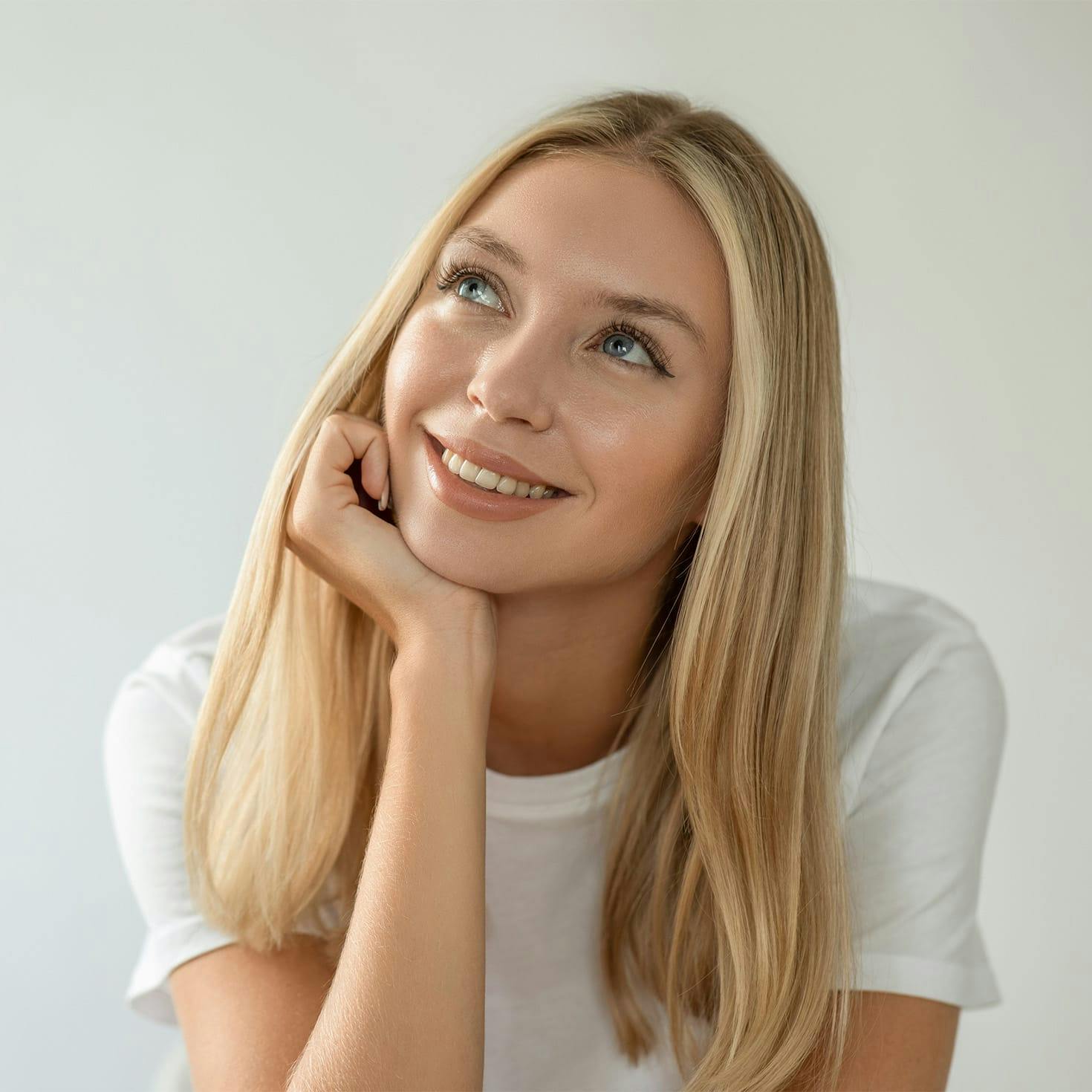 woman smiling, resting her chin on her hand