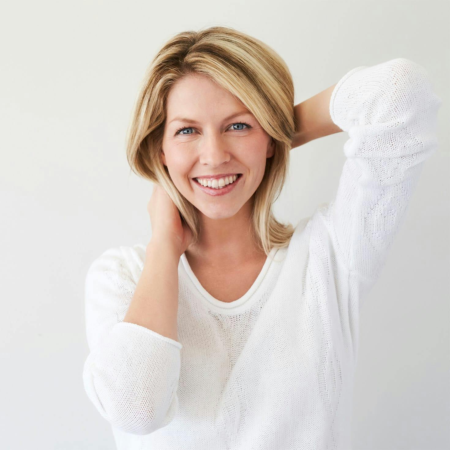 woman smiling, playing with her hair