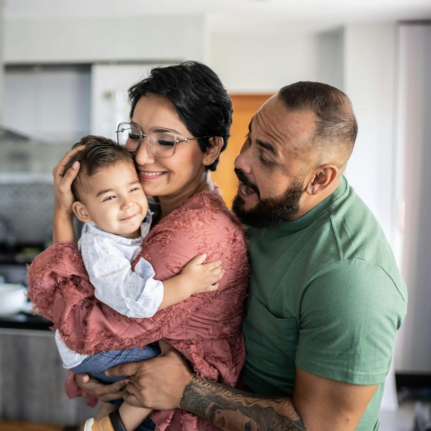 man and woman snuggling a child