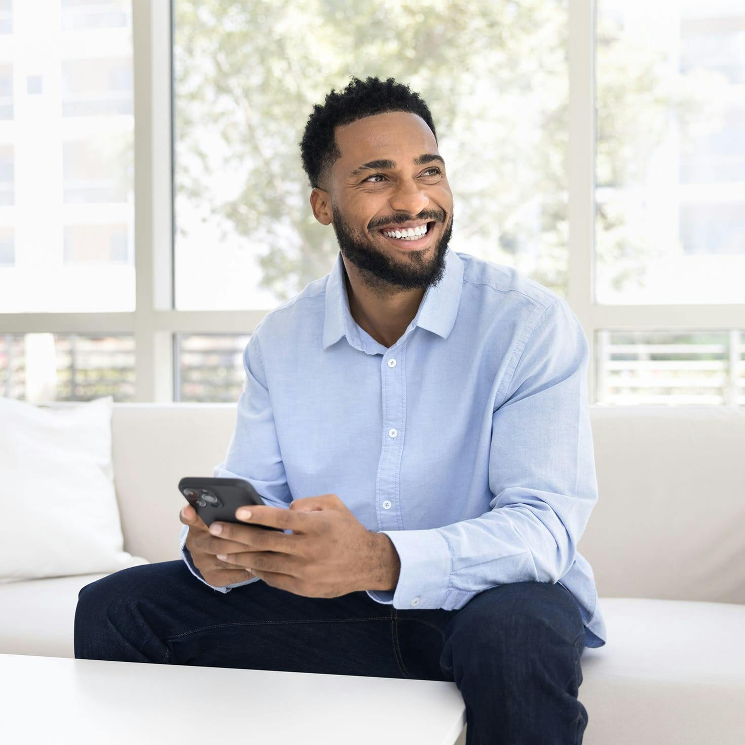 man smiling, holding a phone