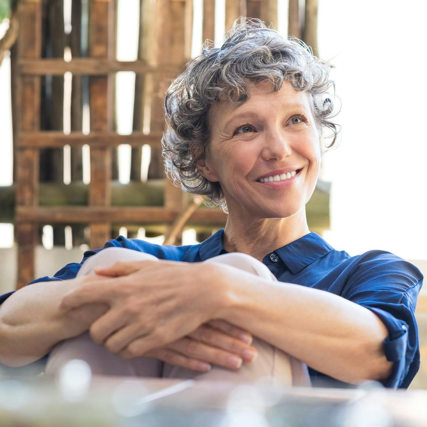 older woman hugging her legs to her chest