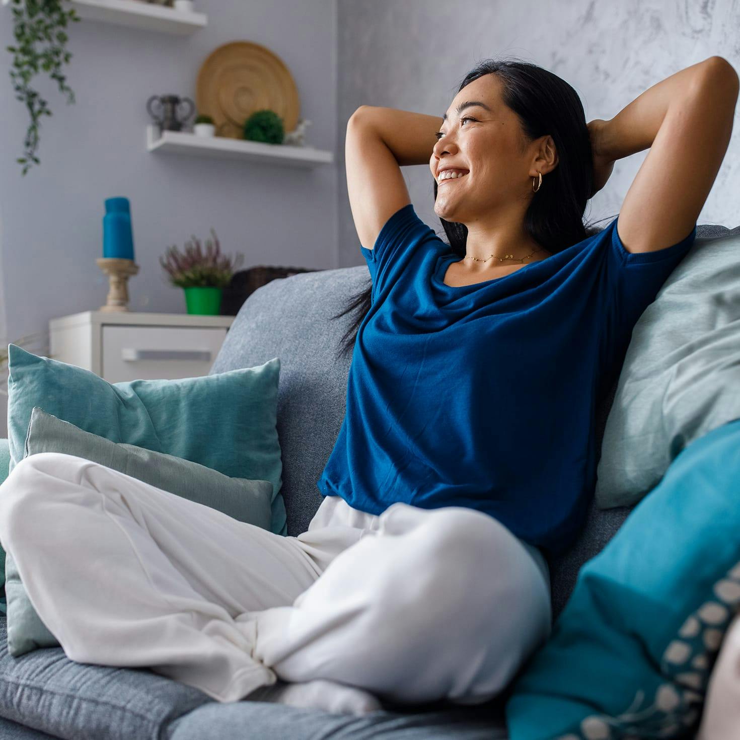 woman sitting in a chair, holding her hands behind her head