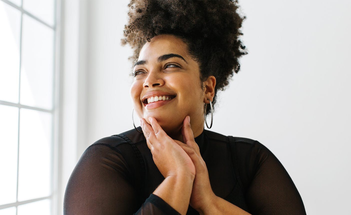 woman smiling, touching her chin