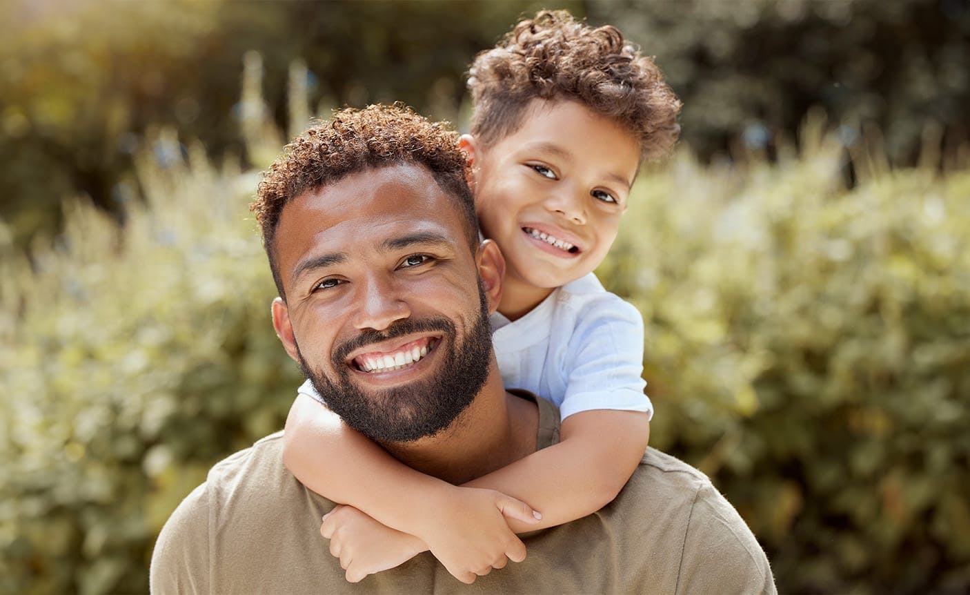 man with a child leaning over his shoulders