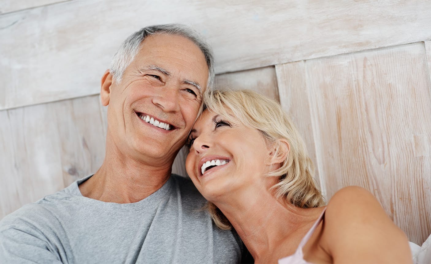 older couple snuggling in a bed