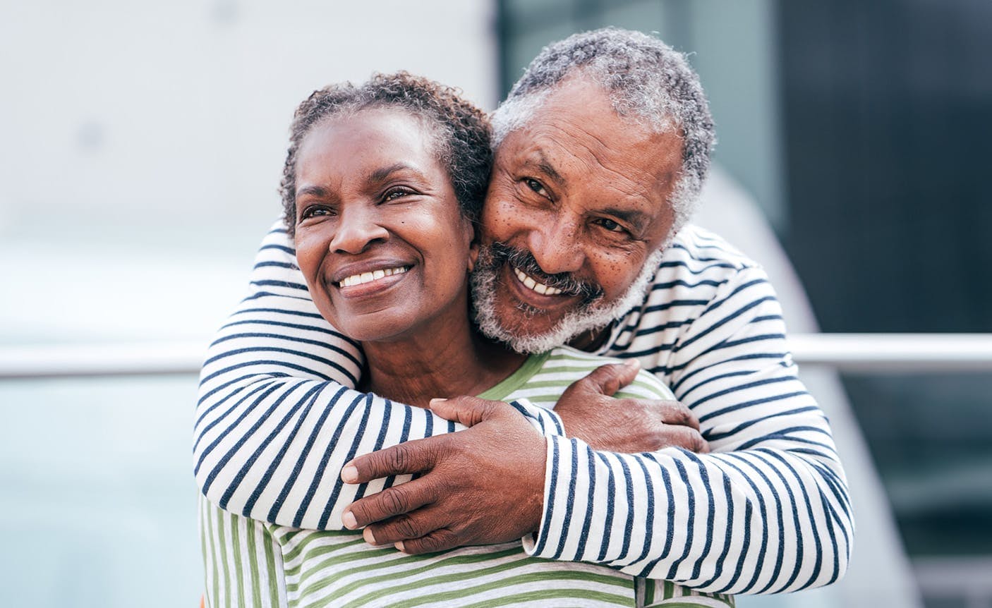 older man hugging an older woman from behind