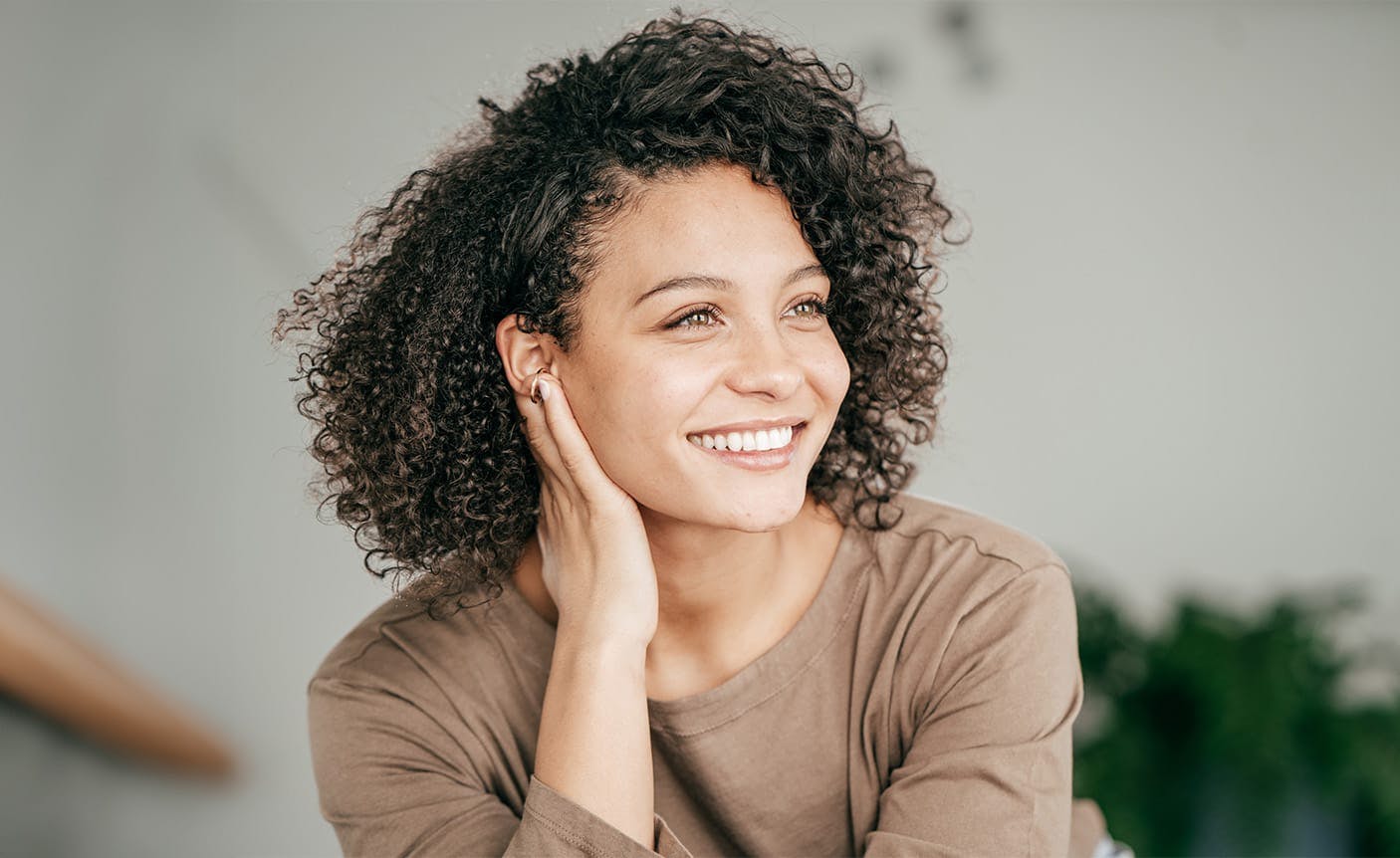 woman smiling, leaning on her hand