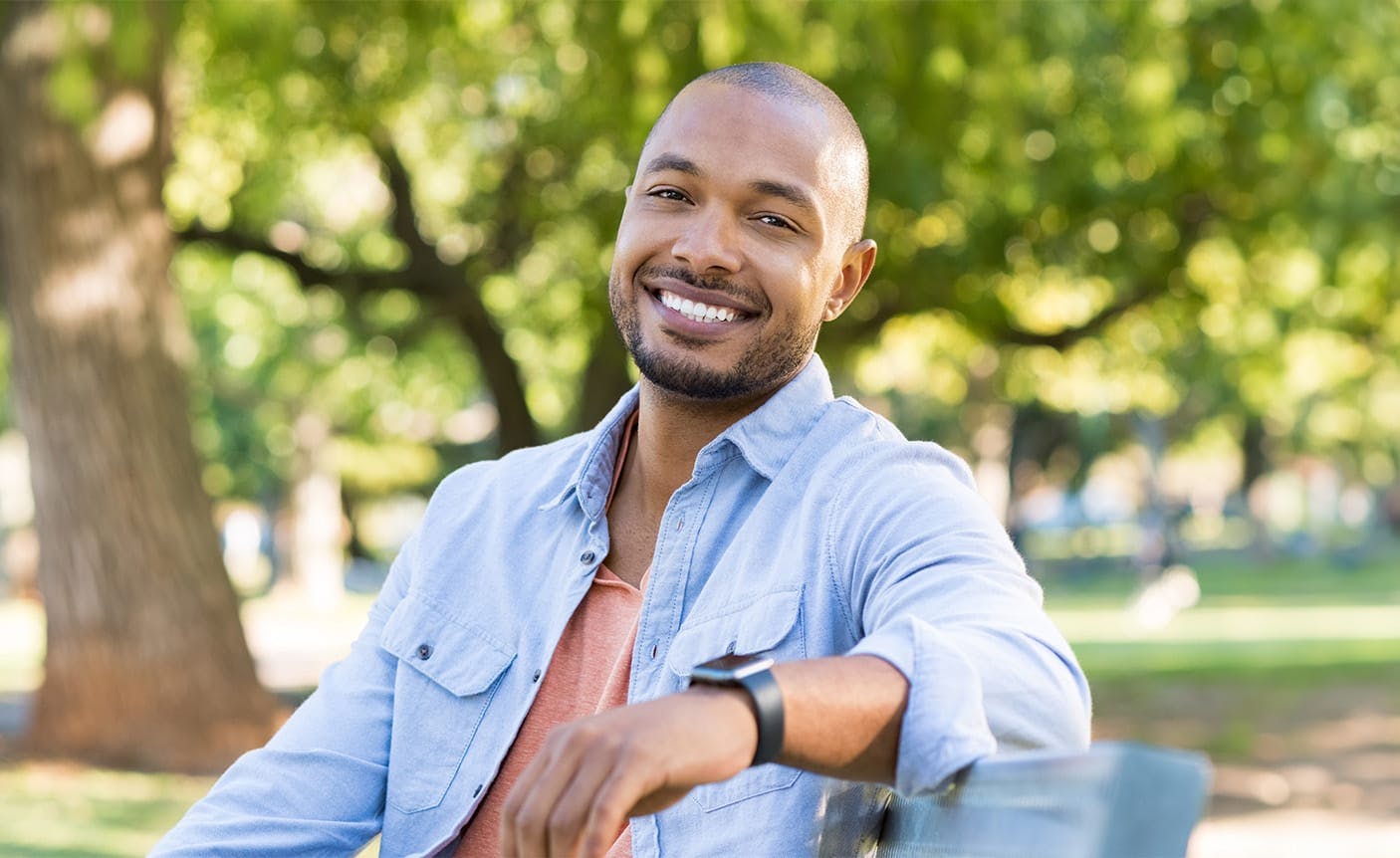 man sitting on a park bench, smiling