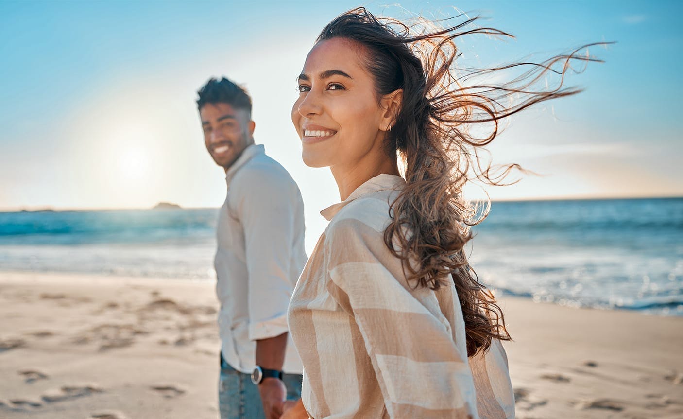 amn and woman walking on a beach